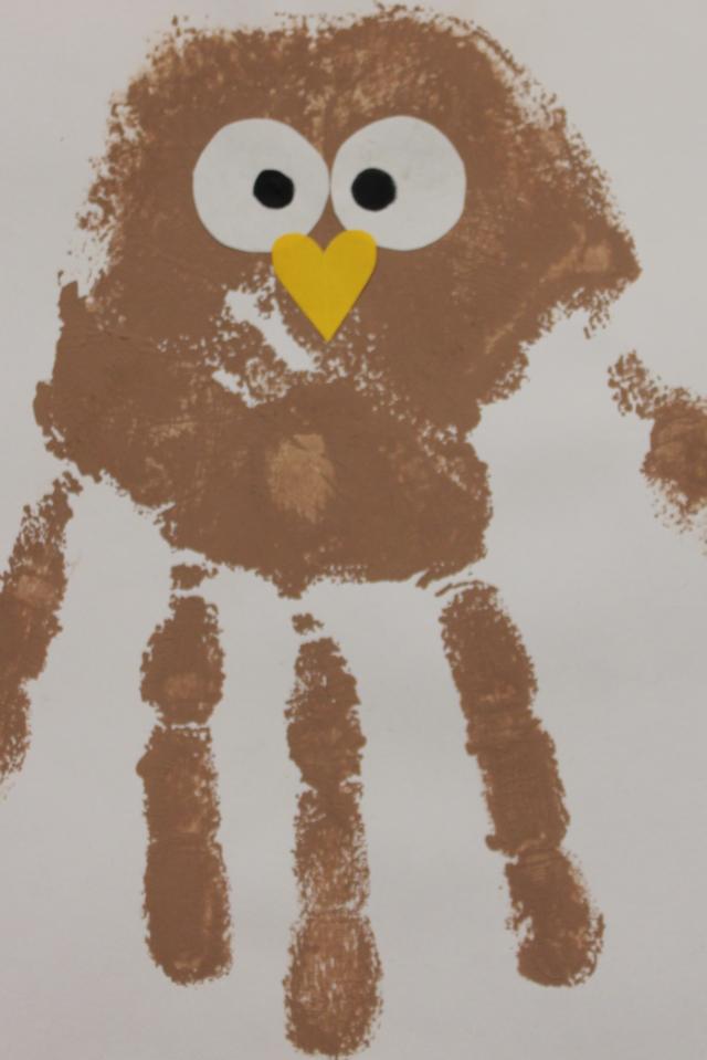 Ruskealla maalilla painettu kädenkuva, jolla olla silmät ja nenä. Teos muistuttaa pöllöä.
